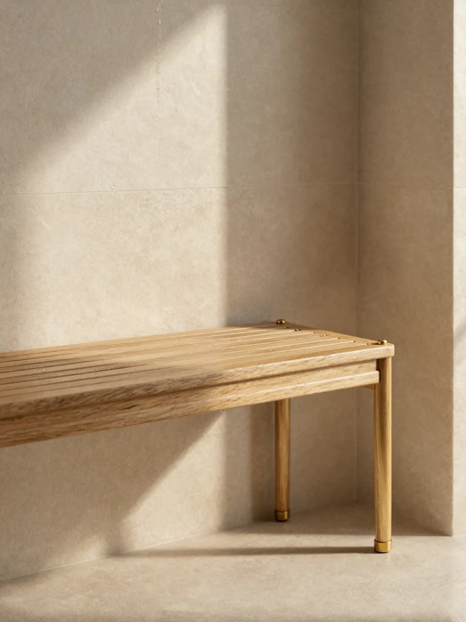 A brushed brass thermostatic shower valve on a linear-drained wet room wall